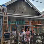 NAIK TANGGA: Salah satu pemilik rumah yang diterjang angin puting beliung (Foto: Humas Polres Sumenep)