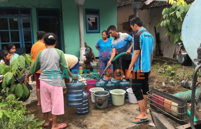 Korban terdampak Banjir Bandang di Desa Wonoasri, Kecamatan Tempurejo, Jember, saat menerima bantuan air bersih.