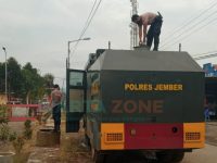 Foto: Anggota Polres Jember, saat mendistribusikan air bersih kepada warga yang terdampak banjir di Kecamatan Tempurejo.