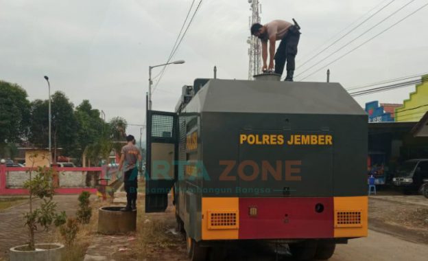 Foto: Anggota Polres Jember, saat mendistribusikan air bersih kepada warga yang terdampak banjir di Kecamatan Tempurejo.