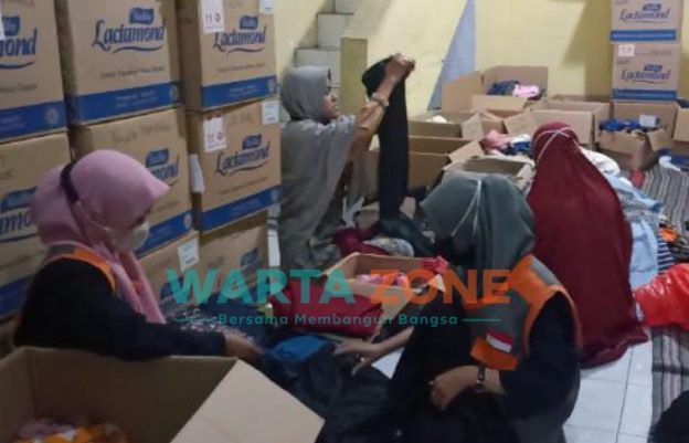 Foto: Anggota Komunitas Bank Klambi, saat memilah pakaian tidak layak pakai.