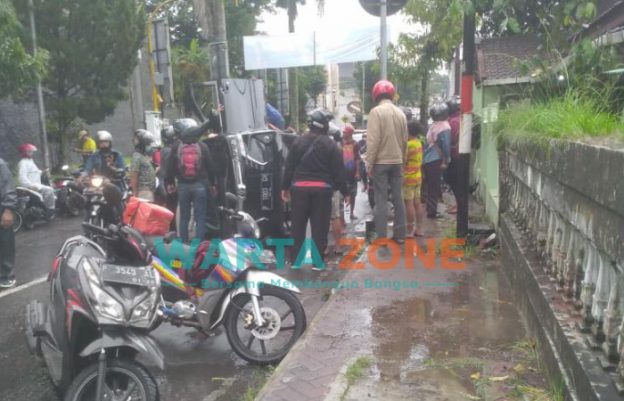 Foto: Sejumlah warga dan pengendara membantu mobil terguling untuk dikembalikan ke posisi semula. Tepatnya di bawah jembatan semanggi di Jalan Bengawan Solo, Jember.