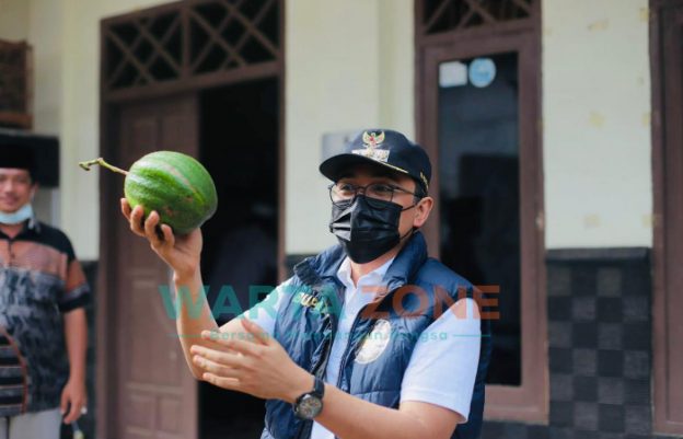 ENERGIK: Bupati Pamekasan, H Baddrut Tamam saat menunjukkan buah alpukat yang merupakan potensi Desa Klompang Timur (Foto: Agus Wandi)