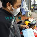 PASRAH: Salah satu pengendara motor saat menunjukkan surat tilang akibat memakai knalpot brong (Foto: Nur Imatus Safitri)