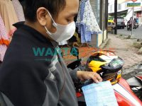 PASRAH: Salah satu pengendara motor saat menunjukkan surat tilang akibat memakai knalpot brong (Foto: Nur Imatus Safitri)