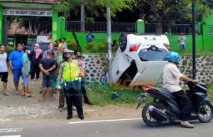 Diduga Mengantuk, Honda Brio Putih Terbalik dan Masuk Parit di Jalan Utama Bondowoso-Jember