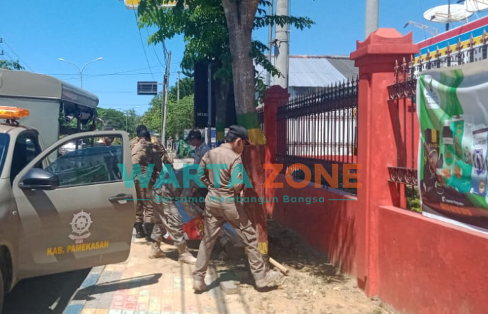 DITERTIBKAN: Anggota Satpol PP Pamekasan saat menertibkan salah satu baliho yang melanggar (Foto: Agus Wandi)