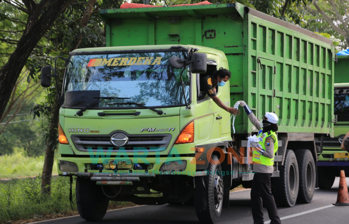 Foto: Srikandi Polda Jatim, saat membagikan masker dan sembako berupa beras di kabupaten Bangkalan. Sekaligus memberi edukasi kepada masyarakat tentang penerapan protokol kesehatan (Prokes) 5M.