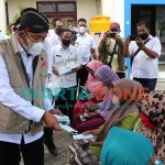 AKRAB: Bupati Sumenep, Achmad Fauzi saat menyapa warga yang sedang mengantre untuk divaksin sembari membagikan masker (Foto: Dok. WARTA ZONE)