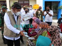 AKRAB: Bupati Sumenep, Achmad Fauzi saat menyapa warga yang sedang mengantre untuk divaksin sembari membagikan masker (Foto: Dok. WARTA ZONE)