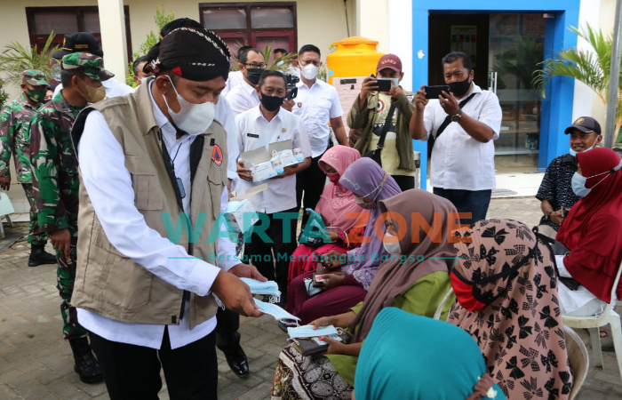 AKRAB: Bupati Sumenep, Achmad Fauzi saat menyapa warga yang sedang mengantre untuk divaksin sembari membagikan masker (Foto: Dok. WARTA ZONE)