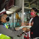 Caption: Anggota Satlantas Polres Jember saat membagikan sembako kepada PKL dan warga di sekitaran terminal Pakusari dan warga Desa Mrawan, Kecamatan Pakusari.