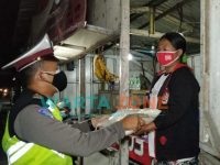 Caption: Anggota Satlantas Polres Jember saat membagikan sembako kepada PKL dan warga di sekitaran terminal Pakusari dan warga Desa Mrawan, Kecamatan Pakusari.