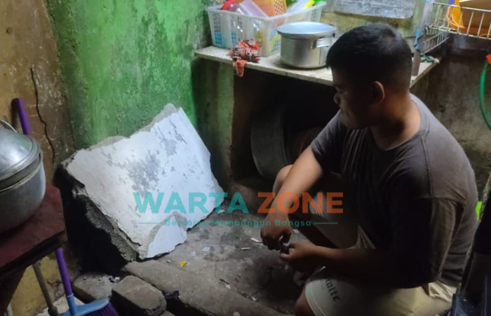 Caption: Reruntuhan dinding tembok Gudang Farmasi Dinkes Jember yang menimpa penghuni rumah milik Gabril Purwadi di bagian dapur.