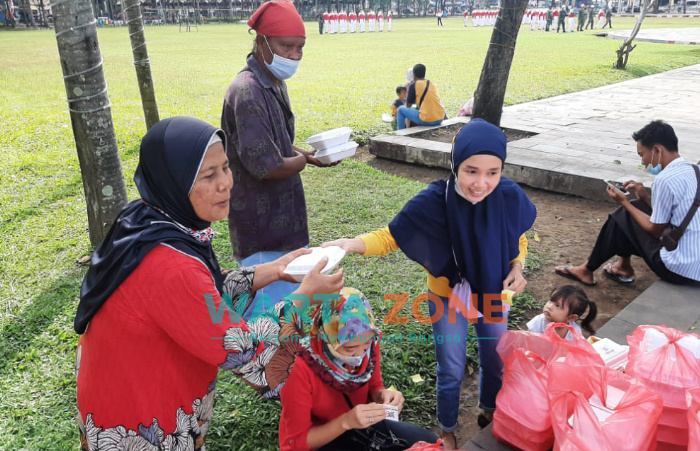 Caption : Pembagian nasi bungkus oleh komunitas Solid Squad di Alun-alun Jember, Jumat (13/8/2021).
