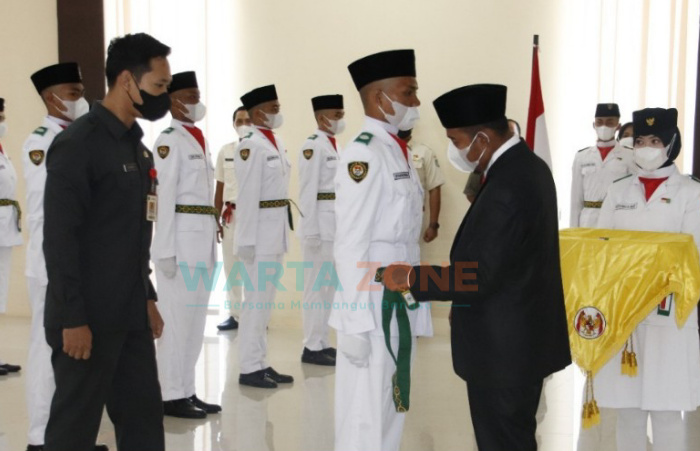 Foto: Bupati Sumenep, Achmad Fauzi, saat mengukuhkan Paskibra Peringatan HUT ke-76 Kemerdekaan RI, di lantai II Gedung Sanika Satyawada, Polres Sumenep.