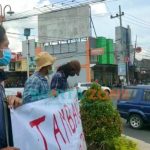 Caption: sejumlah mahasiswa saat melakukan aksi diam dengan membentangkan poster penolakan tambang di bundaran DPRD Jember, Senin (6/9/2021).