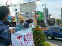 Caption: sejumlah mahasiswa saat melakukan aksi diam dengan membentangkan poster penolakan tambang di bundaran DPRD Jember, Senin (6/9/2021).