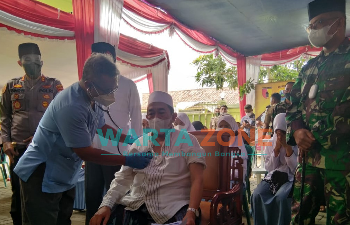 PATUT DICONTOH: Pengasuh Pondok Pesantren Attaufiqiyyah, KH. Imam Hasyim, saat divaksin di lingkungan pesantren (Dok. WARTA ZONE)