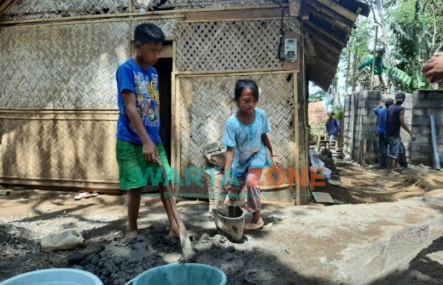 Caption: Tampak kakak beradik, Dedi dan Nur saat sedang bekerja kuli bangunan, Sabtu (18/9/2021).