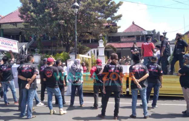 Caption: Tiga elemen yang tergabung dalam pendukung Bupati Jember, Hendy Siswanto, saat melakukan aksi demo di depan Rumah Dinas Pendapa Wahyawibawagraha, Jumat (1/10/2021).