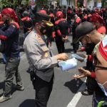 Foto: Kapolrestabes Surabaya, Kombes Pol Akhmad Yusep Gunawan, membagikan masker gratis saat aksi damai buruh tuntut kenaikan upah di Jatim.