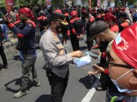 Foto: Kapolrestabes Surabaya, Kombes Pol Akhmad Yusep Gunawan, membagikan masker gratis saat aksi damai buruh tuntut kenaikan upah di Jatim.