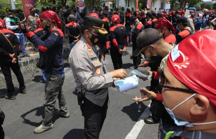 Foto: Kapolrestabes Surabaya, Kombes Pol Akhmad Yusep Gunawan, membagikan masker gratis saat aksi damai buruh tuntut kenaikan upah di Jatim.
