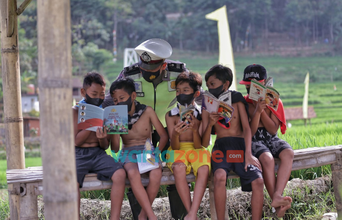 Foto: Babhinkamtibmas Desa Windurejo, Kecamatan Kutorejo, Kabupaten Mojokerto, Aiptu Eriyantono, saat memberikan tambahan edukasi kepada anak-anak yang sedang belajar di tengah pandemi.