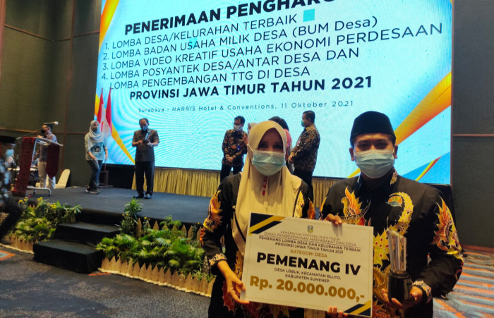 Foto: Kepala Desa Lobuk, Moh Saleh, bersama ketua TP PKK Lobuk, Yusnayati, usai menerima piagam penghargaan Lomba desa dan Kelurahan di Jawa Timur.