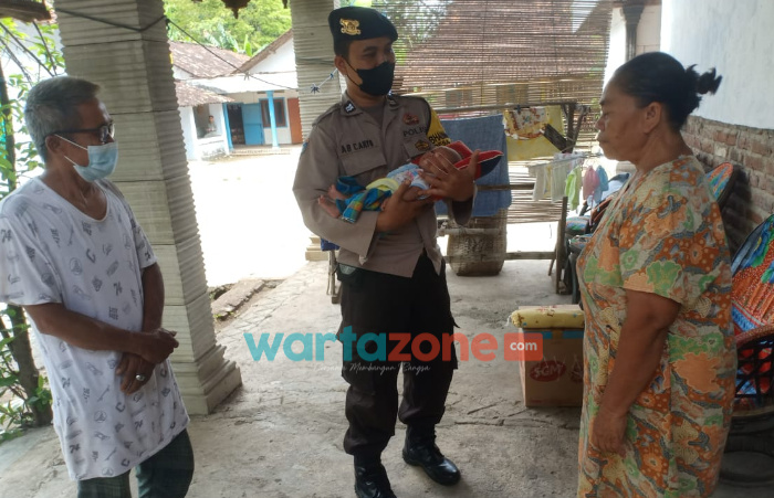 Foto: Bhabinkamtibmas Polsek Mlarak, Kabupaten Ponorogo, Aiptu Agus Bowo Cahyono, saat menjenguk bayi yang berumur 4 hari dilahirkan oleh seorang ibu positif covid-19 dan dinyatakan telah meninggal dunia.