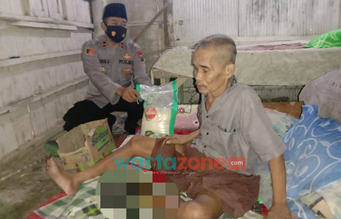 Foto: Bhabinkamtibmas Desa Rong Dalam, Bripka Khoirul Anam, saat mendatangi rumah Sadiman (65), yang mengalami sakit pada kakinya setelah menginjak tulang ular saat melakukan aktifitas berkebun.