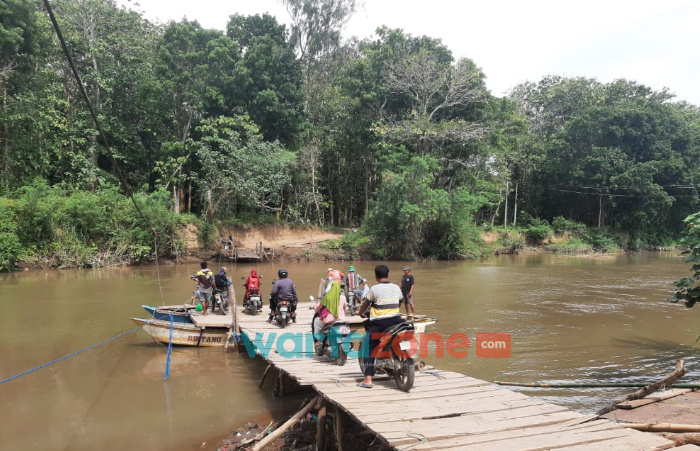 Foto: Sejumlah warga yang sedang menyeberangi sungai menggunakan perahu getek, penghubung dua Dusun dan Dua Desa di Jember, Senin (8/11/2021) siang.