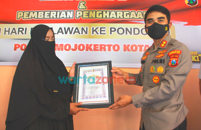 Foto: Kapolresta Mojokerto, AKBP Rofiq Ripto Himawan, saat memberikan penghargaan kepada Sriasih (41), Pengasuh Pondok 99 di Dusun Pandantoyo, Desa Pandankrajan, Kecamatan Kemlagi.