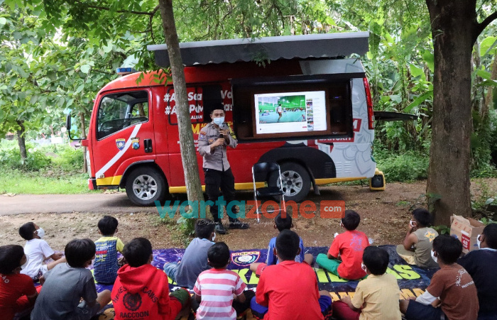 Foto: Bhabinkamtibmas Desa Sembilangan, Bripda Herlambang Wahyu Anafis Satriatama, saat memberikan kelas tambahan anak anak SD di Bangkalan.