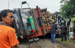 Hindari Jalan Berlubang, Fuso Bermuatan Kayu Sengon Oleng, Tabrak L300 dan Warung Es