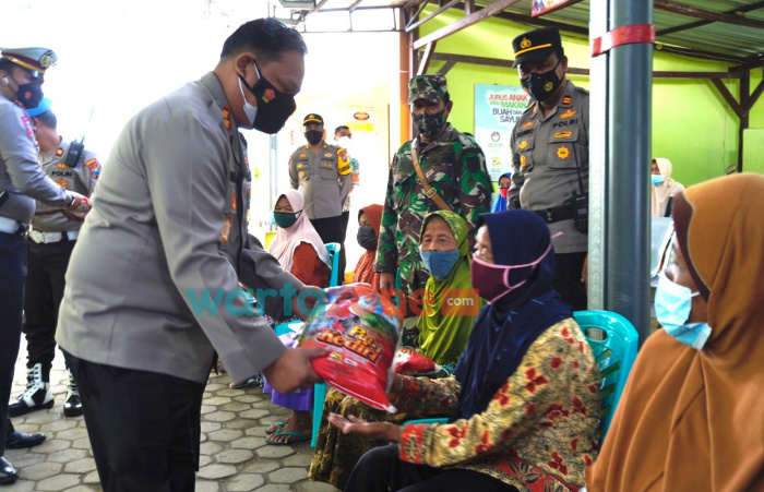 Foto: Kapolres Bojonegoro, AKBP EG Pandia, saat menyalurkan paket sembako disela pelaksanaan vaksinasi lansia, di Gerai Vaksinasi Puskesmas Temayang.