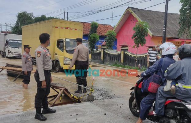 Foto: Personil Polres Bangkalan dan tim Posek Blega, saat mengurai kemacetan akibat genangan air.