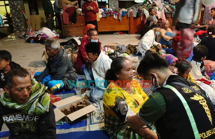 Foto: Tim Kedokteran dan kesehatan Polres Lumajang bersama RS Bhayangkara, saat memeriksa korban erupsi Semeru di lokasi pengungsian.