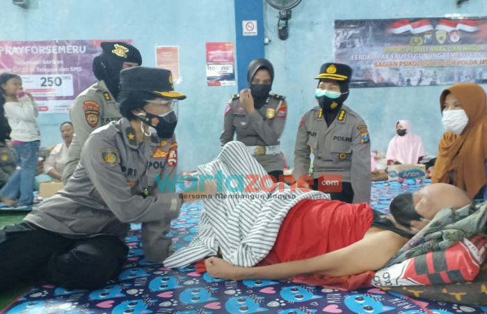 Foto: Salah satu perwira Polwan RI saat mengunjungi korban terdampak erupsi Gunung Semeru.