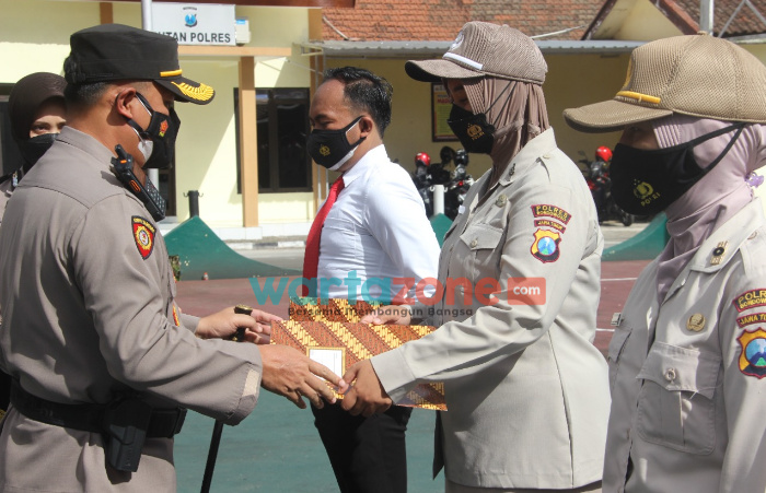 Foto: Kapolres Bondowoso, AKBP Herman Priyanto, saat menyerahkan penghargaan 12 anggota polisi berprestasi.