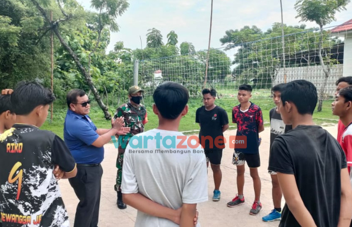 Foto: Kades Banbaru, Zainal Abidin bersama Babinsa setempat, menyambangi para pemuda di lapangan bola voli untuk diberi edukasi vaksin.