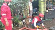 Foto: Tim wash PMI Kabupaten Jember saat melakukan pembersihan lumpur di depan rumah warga yang terdampak banjir bandang, Selasa (11/1/2022).