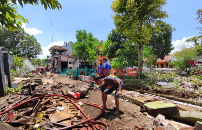 Foto: Petugas pemadam kebakaran, saat membantu warga membersihkan sisa lumpur yang terdampak bencana banjir bandang, Selasa (11/1/2022).