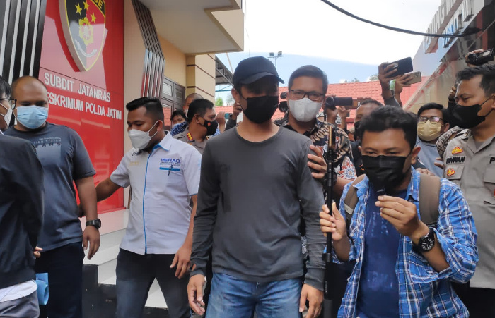 Foto: Pelaku penendang sesajen yang viral di media sosial saat diamankan oleh Ditreskrimum Polda Jatim.