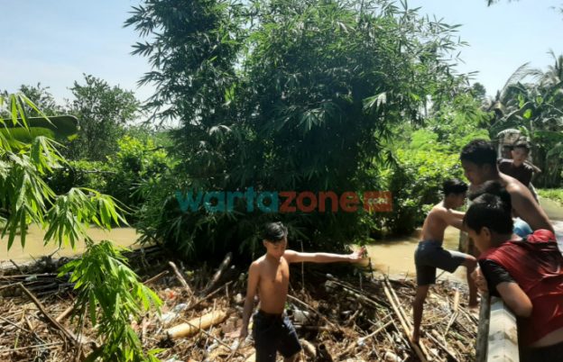 Foto: Tampak bambu-bambu yang menyumbat di aliran sungai, Jumat (14/1/2022).