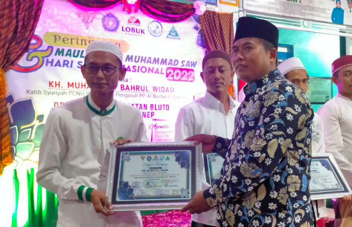 Foto: Kepala Desa Lobuk Moh. Saleh saat menyerahkan piagam penghargaan kepada sejumlah pimpinan lembaga pendidikan.