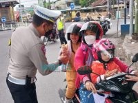 Pantau Arus Lalin di Perempatan Jalan, Polisi di Jember Bagikan Coklat ke Anak-Anak