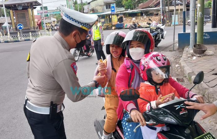 Pantau Arus Lalin di Perempatan Jalan, Polisi di Jember Bagikan Coklat ke Anak-Anak
