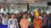 Foto: Saat Kepala BPN Kabupaten Nias, Sekda Kabupaten Nias dan Anggota DPR RI Komisi II (kiri-kanan) foto bersama masyarakat penerima sertifikat tanah.